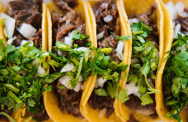 Tacos de carne asada con cebolla picada y cilantro