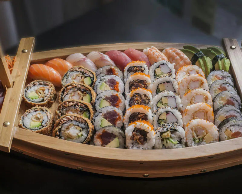 Barca de madera con rollos de sushi variados