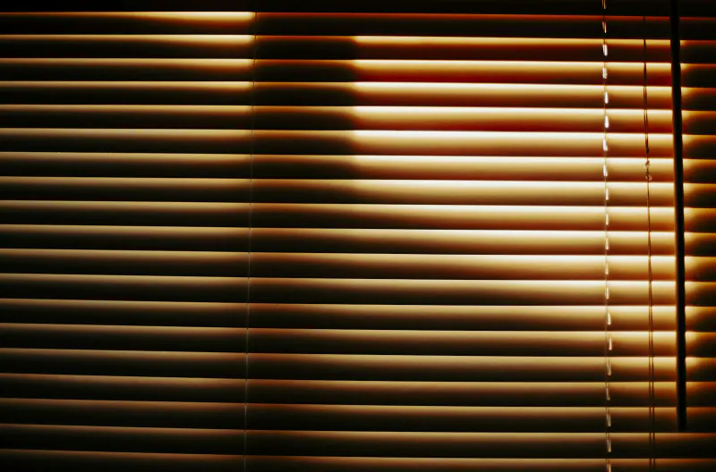 Persiana horizontal de madera con luz cálida filtrándose