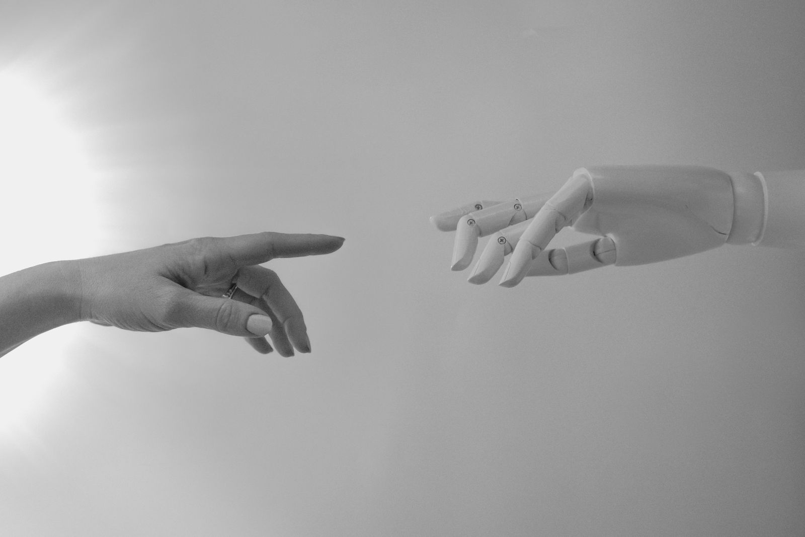 Mano humana y mano robótica acercándose, curso de inteligencia artificial para marketing