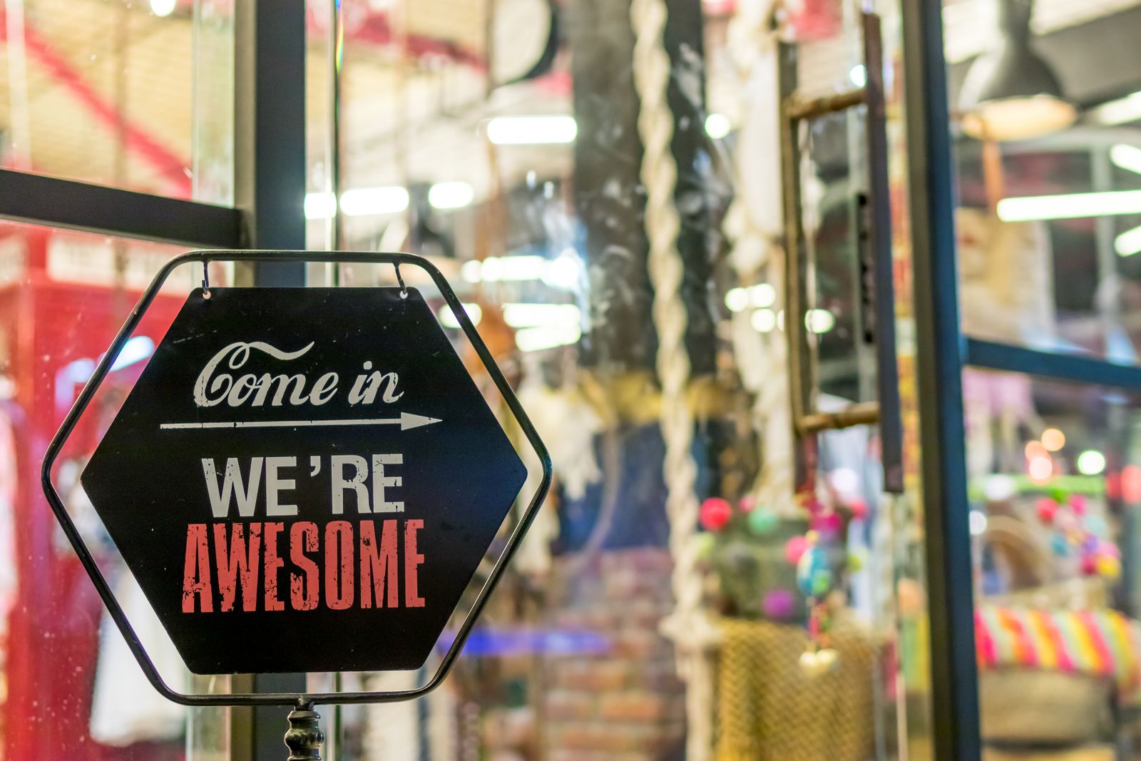 Letrero de un negocio local con la frase come in we're awesome, ejemplo de presencia local