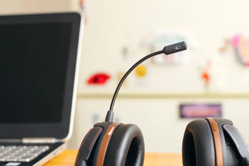 Diadema con micrófono de atención telefónica junto a una laptop sobre un escritorio