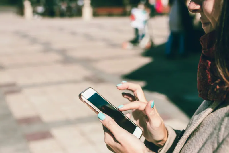 Woman scrolling a website on her smartphone outdoors