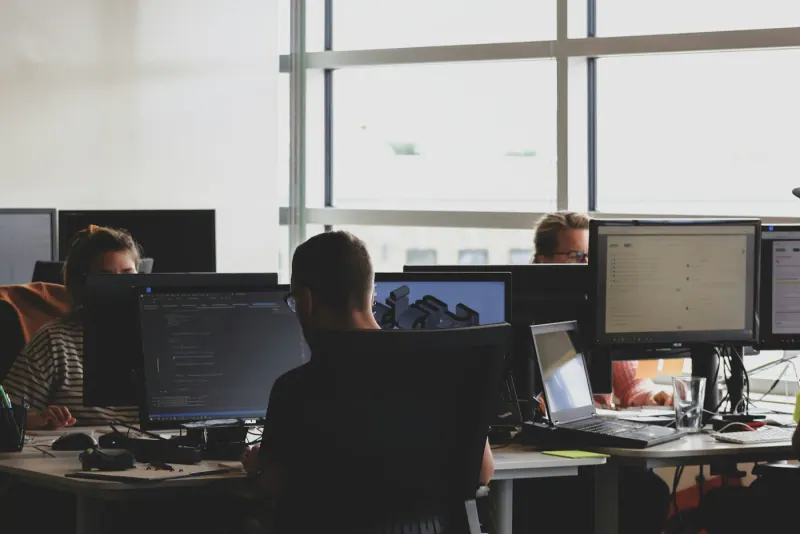Developers working at computer monitors in a bright open office