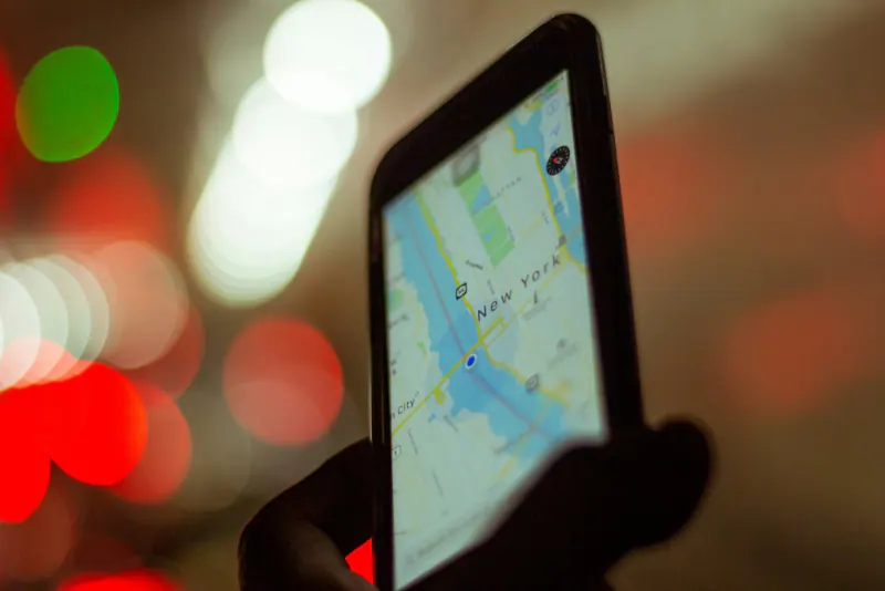 Mano sosteniendo un celular con un mapa abierto de noche