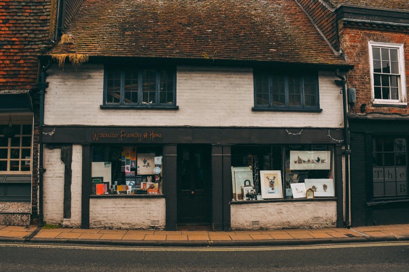 Storefront of a small retail shop with display windows and a dark door
