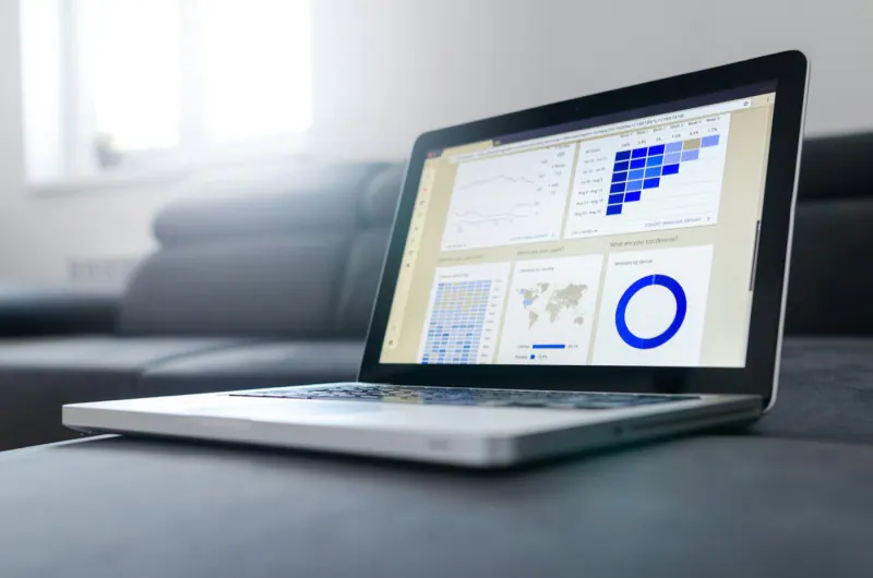 Laptop sobre un sillón mostrando un tablero de analítica con gráficas