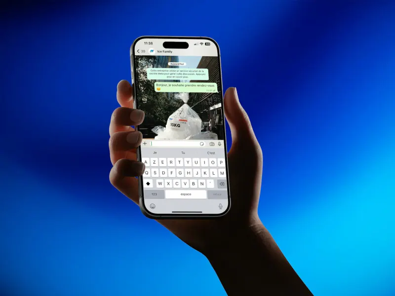 A hand holds a smartphone with an open messaging conversation against a blue background
