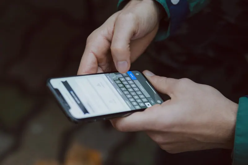 Hands typing a message on a phone to help a customer