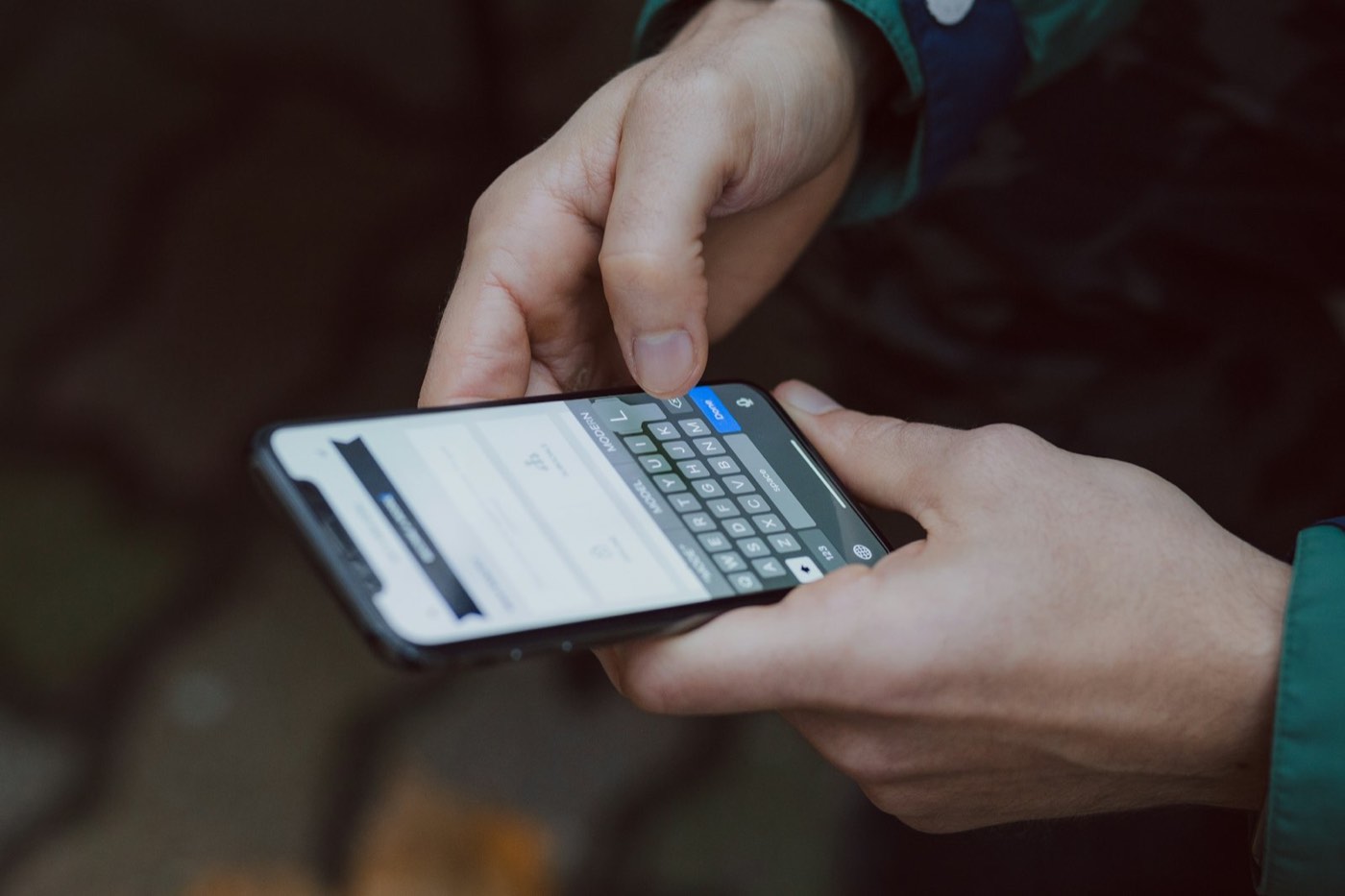 Manos escribiendo un mensaje en un celular para atender a un cliente