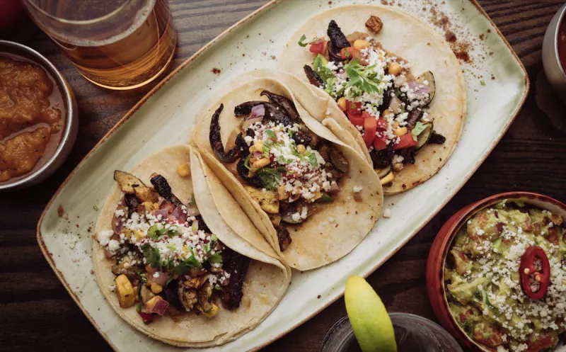 Plate of tacos served on a restaurant table, ready to order from a digital menu