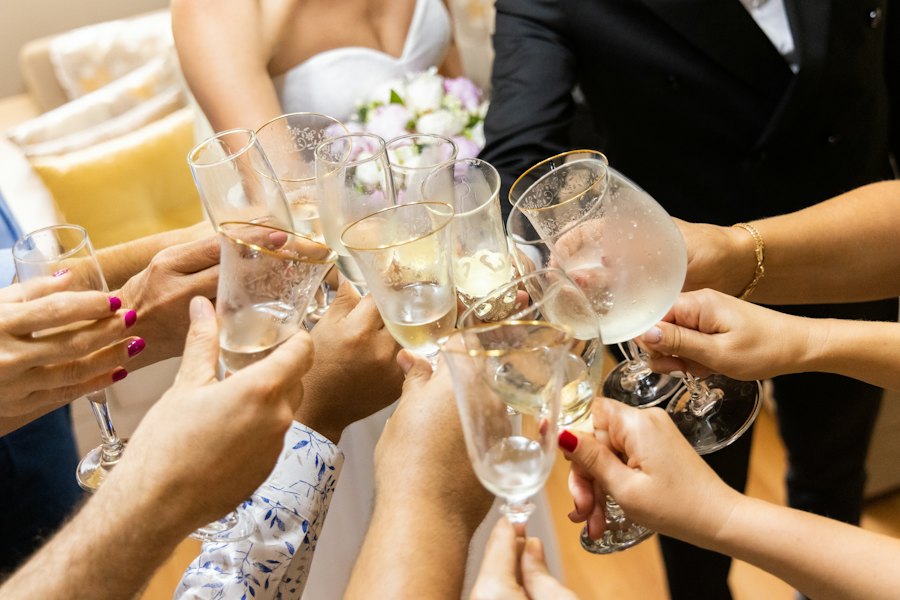 Invitada con vestido largo brindando con una copa de vino