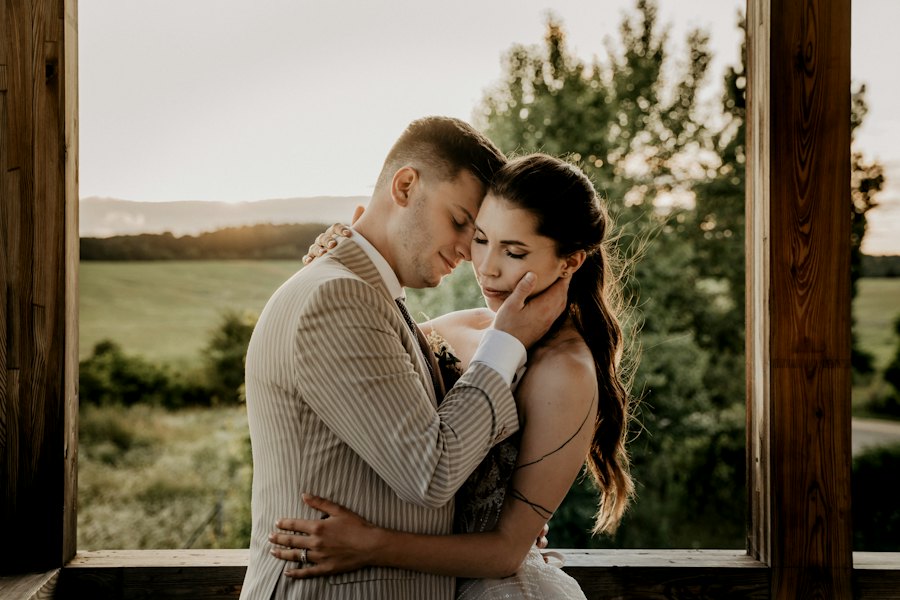 Retrato de los novios junto a una ventana de luz cálida