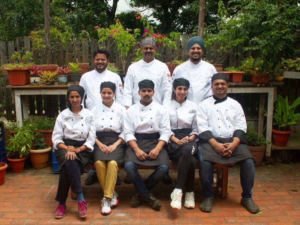 Equipo de cocineros posando con filipinas blancas