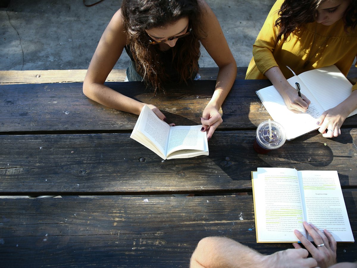 Estudiantes de preparatoria leyendo y tomando notas en una mesa