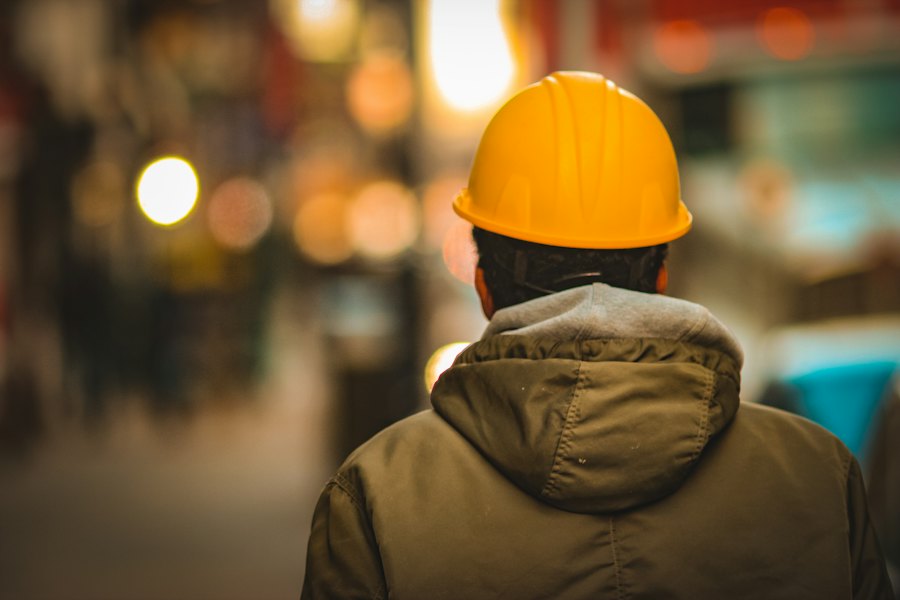 Supervisor de obra con casco amarillo de espaldas en el sitio
