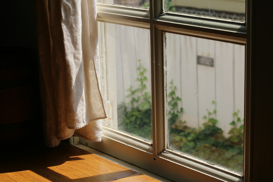 Ventana con cortina iluminada por el sol de la tarde