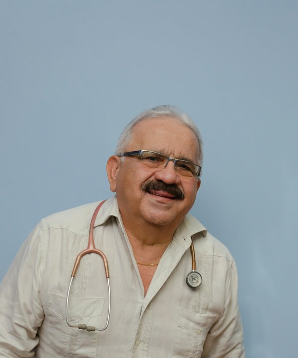 Médico de bigote y lentes con camisa clara y estetoscopio