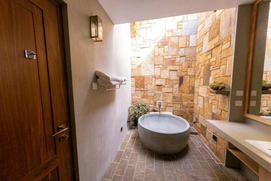 Baño con muro de piedra y tina
