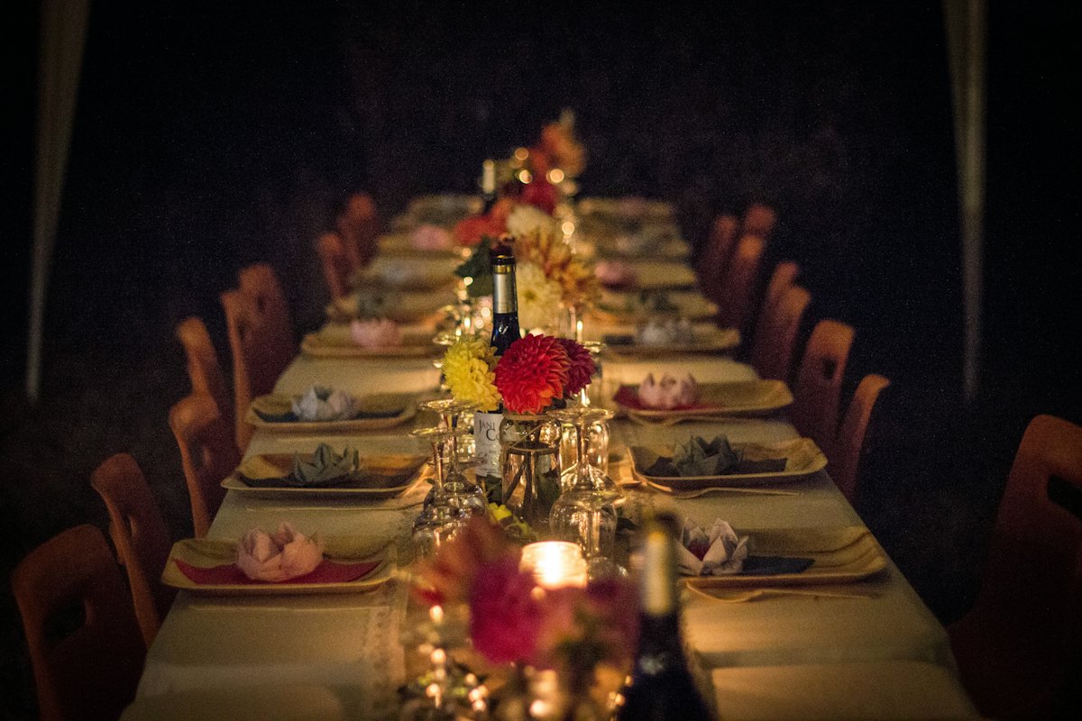 Mesa larga montada para cena con flores y velas
