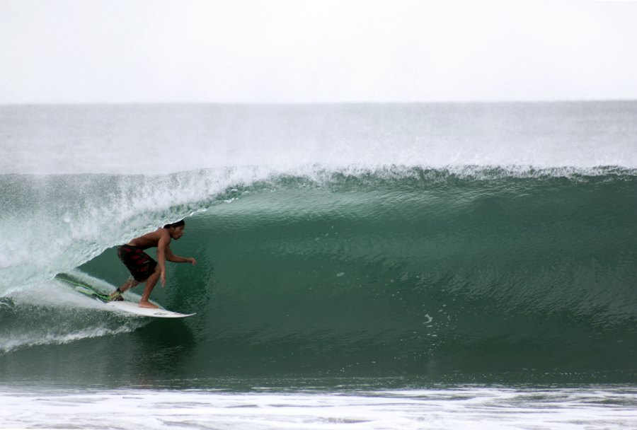 Surfista sobre una ola verde