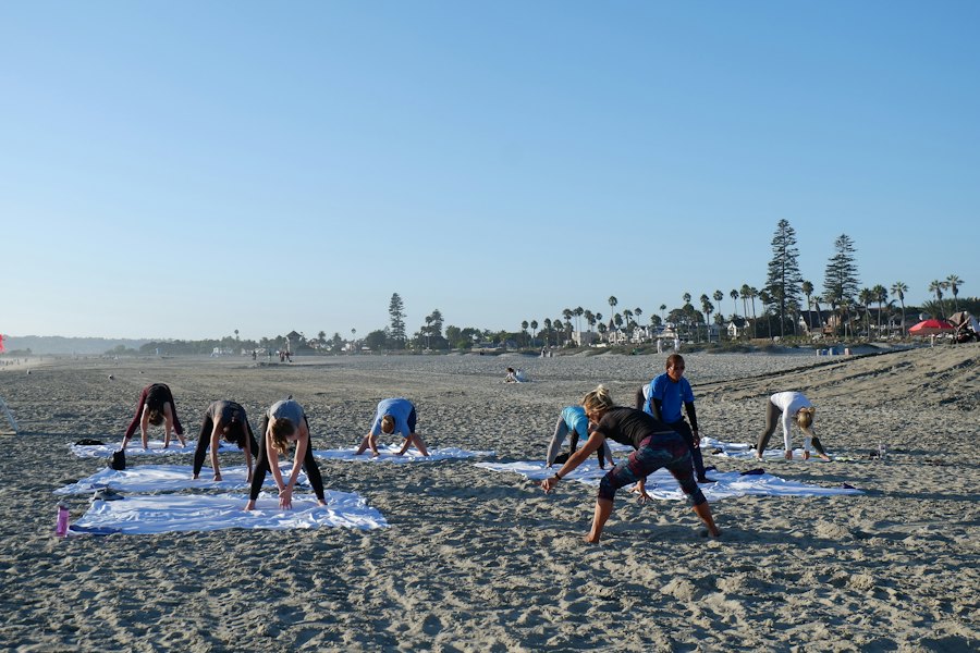 Grupo practicando yoga en la playa