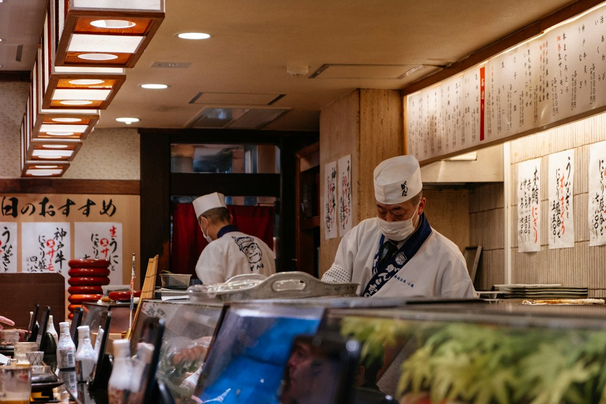 Cocineros preparando sushi detrás de la barra de madera