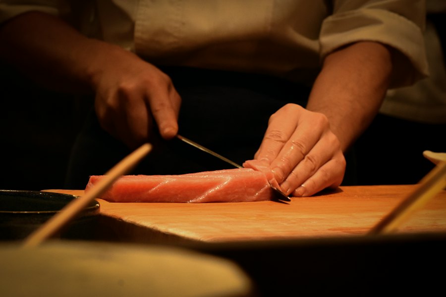 Chef cortando pescado sobre tabla de madera