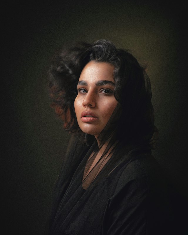 Mujer de cabello oscuro rizado sobre fondo negro