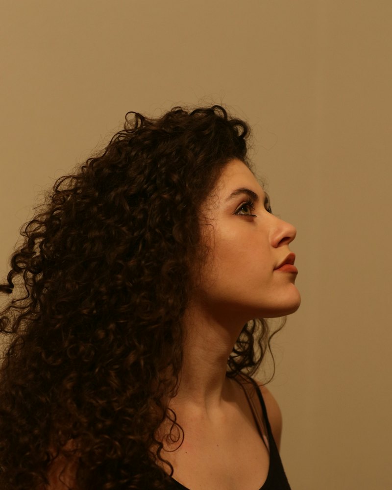 Mujer de perfil con rizos definidos y voluminosos