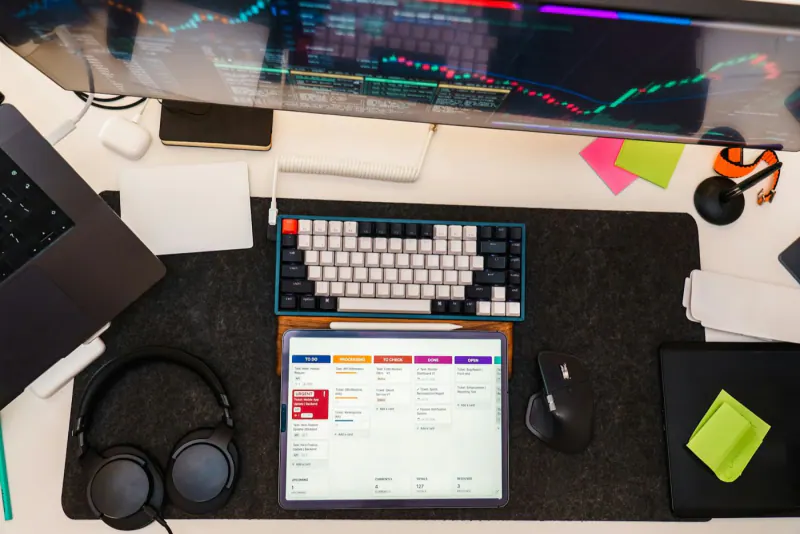Desk with a monitor, keyboard and tablet showing a dashboard of automated tasks