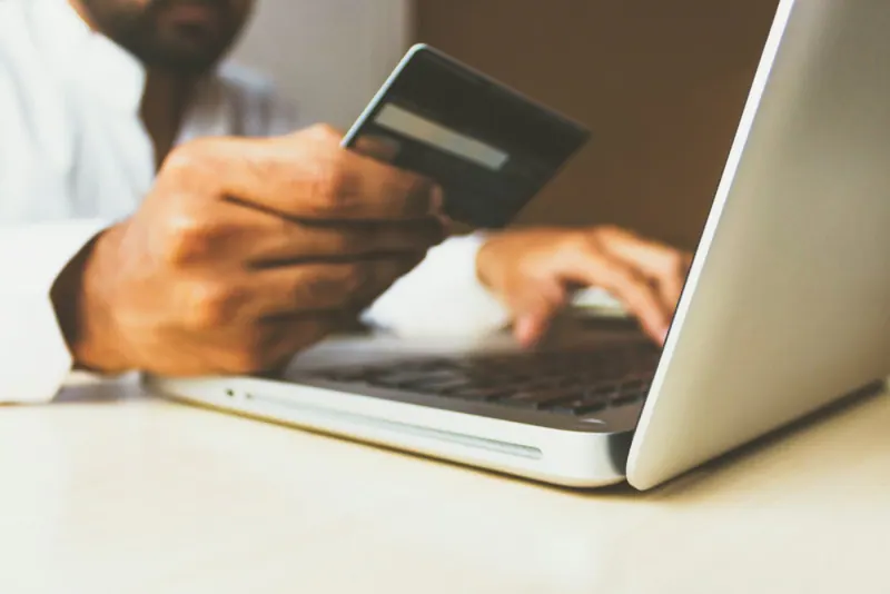 Person paying by card for an online purchase on a laptop