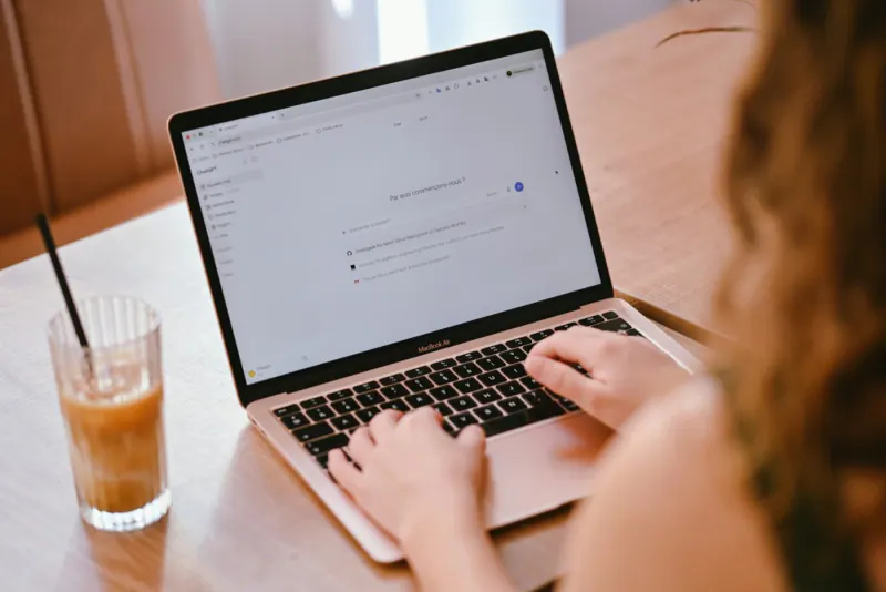 Person typing a question to an AI assistant on a laptop