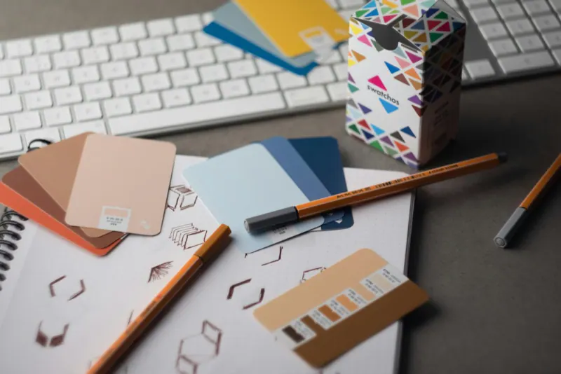 Design desk with color swatches, pencils and sketches for a brand identity